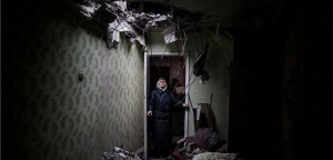 Η Γκαλίνα, 86 ετών, κοιτάζει την τρύπα που άφησε η οβίδα που χτύπησε την πολυκατοικία και κατέστρεψε το διαμέρισμά της στην περιοχή Κιέβσκι, στο Ντόνετσκ της ανατολικής Ουκρανίας. (Περιοχή του Ντόνετσκ, Ουκρανία, Ιανουάριος 2015, ©Manu Brabo)