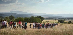 Μια ομάδα περίπου 150 προσφύγων από τη Συρία ξεκίνησαν να διασχίσουν τα ελληνικά σύνορα με την ΠΓΔΜ, με την ελπίδα να υποβάλουν αίτηση για άσυλο σε χώρες όπως η Γερμανία ή η Σουηδία. Το ελληνικά σύνορα με την ΠΓΔΜ ολοένα και περισσότερο πέφτουν στον έλεγχο των διακινητών και κάθε μέρα γίνονται λιγότερο ασφαλή. Για τον λόγο αυτό, οι πρόσφυγες προσπαθούν να περάσουν τα σύνορα σε μεγάλες ομάδες ώστε να μπορούν να υπερασπιστούν τον εαυτό τους. (Περπατώντας προς το Βορρά, Ειδομένη, Ελλάδα, Ιούνιος 2015, ©Alessandro Penso)