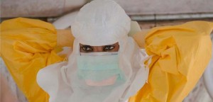Μέλος του προσωπικού των Γιατρών Χωρίς Σύνορα φορά την προστατευτική στολή πριν εισέλθει στη ζώνη υψηλού κινδύνου του Κέντρου Διαχείρισης Θεραπείας Έμπολα «Ντόνκα» στο Κόνακρι της Γουινέας. (Νοσοκομείο Ντόνκα, Κονακρί, Γουινέα, Ιανουάριος 2015, ©Yann Liebessart/MSF)